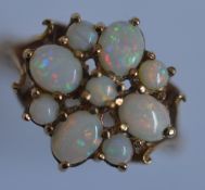 A heavy opal cluster ring in 9 carat mount. Approx. 4.3 grams. Est. £50 - £60.