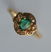 A small emerald and diamond oval cluster ring in 1