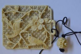 A small carved ivory pendant decorated with a bird. Est. £15 - £20.