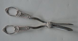 A pair of silver grape scissors with pierced handl