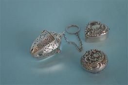 A small scroll decorated tea infuser with hinged t