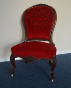 A ladies scroll decorated button back chair with c
