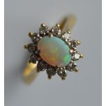 An oval opal and diamond cluster ring in 18 carat