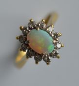 An oval opal and diamond cluster ring in 18 carat