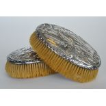 A pair of good embossed hairbrushes decorated with