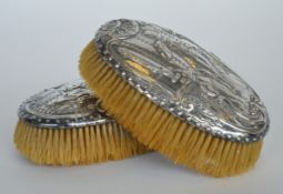 A pair of good embossed hairbrushes decorated with