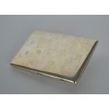 A heavy silver cigar case with hinged decoration a