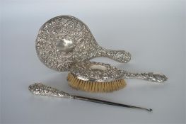 An embossed silver backed brush together with a mi