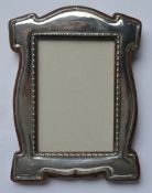 A stylish picture frame with wavy edge and reeded border. Approx. 20 cms high. By BB&DC. Est. £150 -