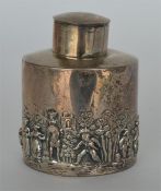 A circular embossed caddy decorated in figures, wi