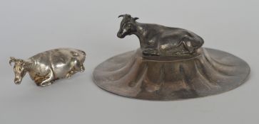 An unusual silver preserve stand lid, mounted with a cow, together with one other. Est. £30 - £40.