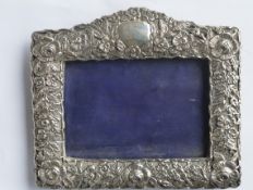 An attractive embossed rectangular picture frame decorated with flowers and scrolls. Approx. 19 cms.