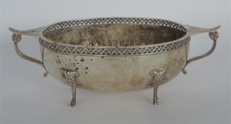 A.E. JONES. A large oval sweet dish with textured body and pierced rim with four hoofed feet.