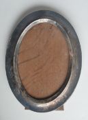 An oval silver picture frame with oak panelled back. Birmingham. By SM&Co. Approx. 17 cms high. Est.