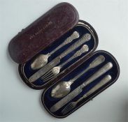 A cased three piece Kings' pattern christening set, together with one other cased set. London. By