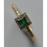 An emerald and diamond cluster ring in 18 carat tw