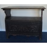 A small oak carved settle with hinged top and reed