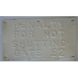 A pressed metal sign "Penalty for not shutting gat