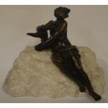A small bronze figure of a seated man on rugged st
