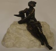 A small bronze figure of a seated man on rugged st