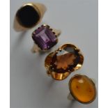 A heavy group of four 9 carat rings inset with gem