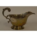A small pedestal sauce boat with scroll handle and