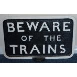 A cast iron sign "Beware of the Trains", on a circ