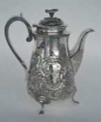 A George III coffee pot with floral embossed decor