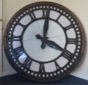 An unusual large cast clock face in wooden surroun