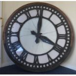 An unusual large cast clock face in wooden surroun