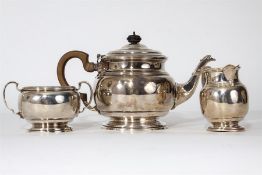 A heavy three piece tea service of circular form.