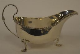 A good sauce boat on three legs with beaded border