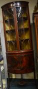 A mahogany bow front corner cupboard with bevelled
