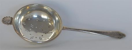 A small stylish tea strainer with shell thumb piec