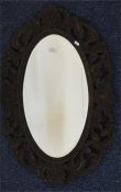 A small oak framed mirror with carved decoration.