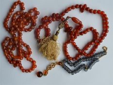 A collection of three hard stone necklaces with ta