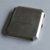 A small silver cigarette case with cut corners. Bi