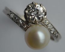 A diamond and natural pearl crossover ring set in