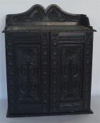 A small oak hanging cupboard with carved decoratio