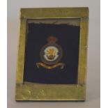 A Royal Sir Force insignia mounted in a brass fram