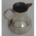 A small helmet shaped half fluted cream jug. Londo