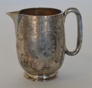 An attractive engraved cream jug decorated with fl