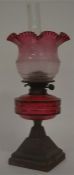 An attractive cranberry glass oil lamp decorated w