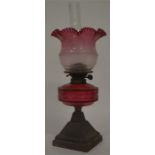 An attractive cranberry glass oil lamp decorated w