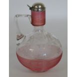 An attractive cranberry glass decanter with hinged