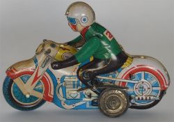A small mechanical toy in the form of a motor cycl
