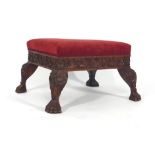 An Anglo-Indian padouk and upholstered dressing stool with a foliate carved frieze on paw feet