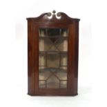 A late 18th/early 19th century mahogany corner cupboard,