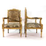 A pair of French Louis XVI-type giltwood and upholstered armchairs with square backs on arrow feet