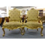 A pair of Louis XV-style florally carved giltwood and upholstered saloon armchairs